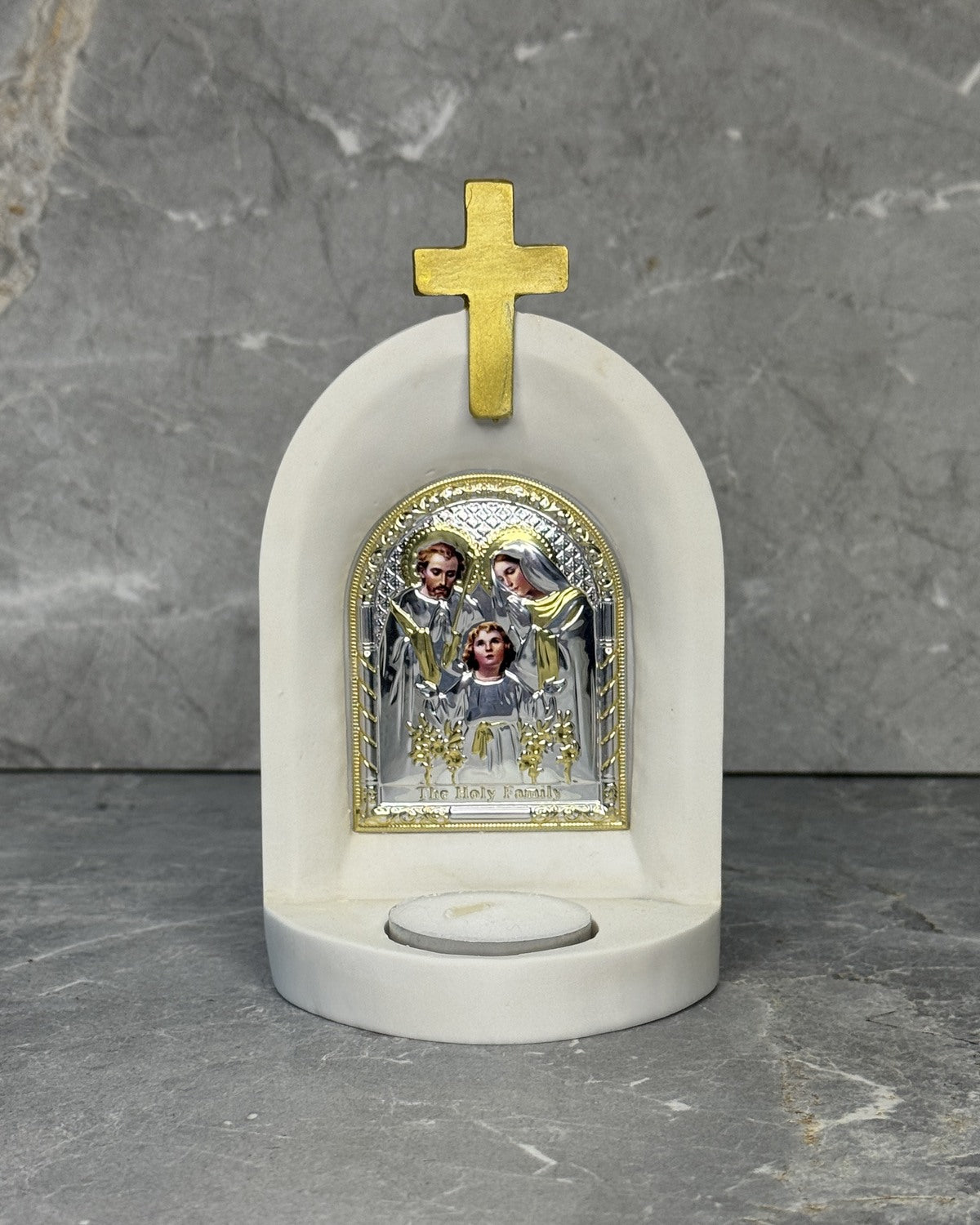 White stone Catholic candle altar with gold Holy Family icon