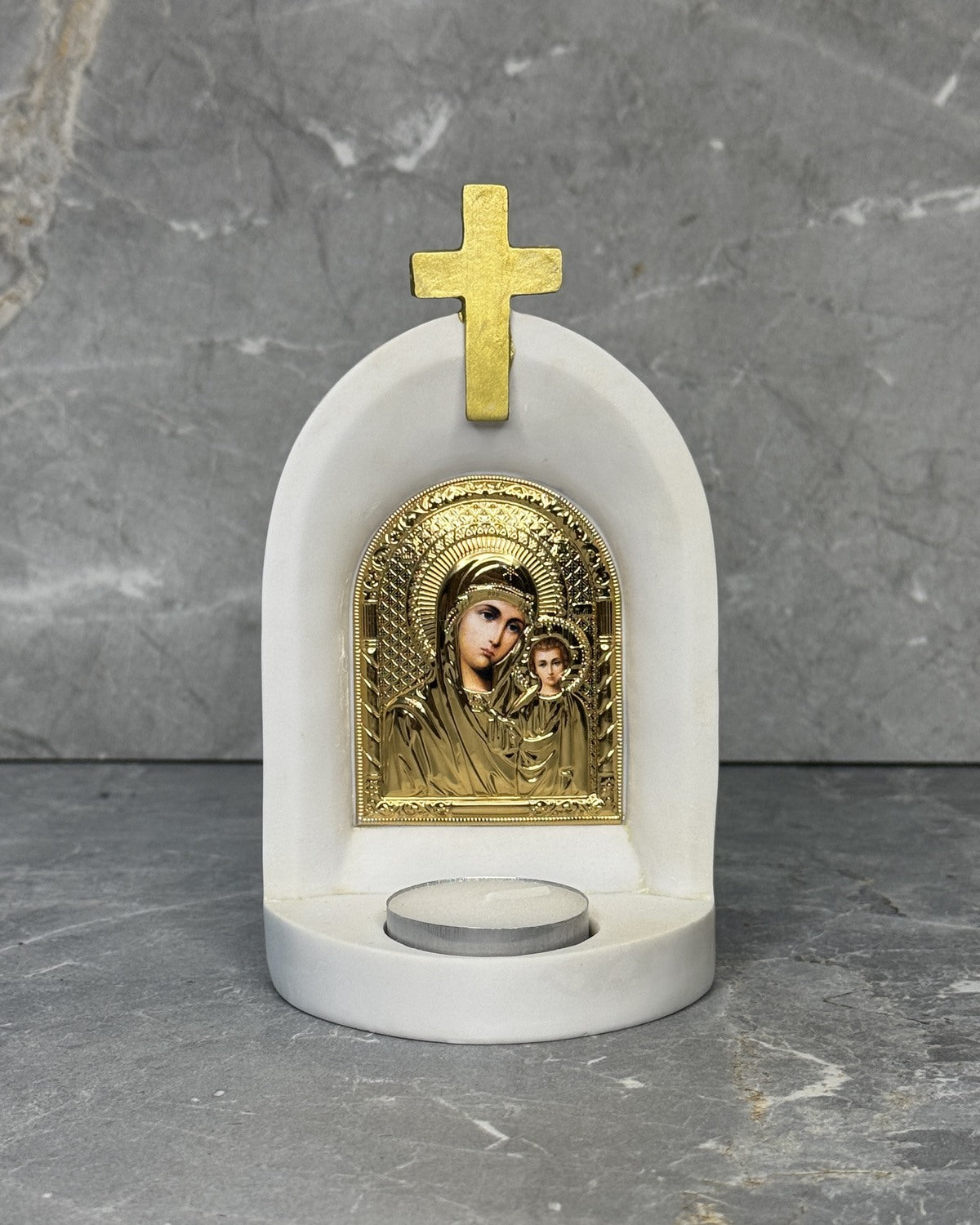 White stone Catholic candle altar with gold Panagia Kazan icon of Mother Mary and Jesus