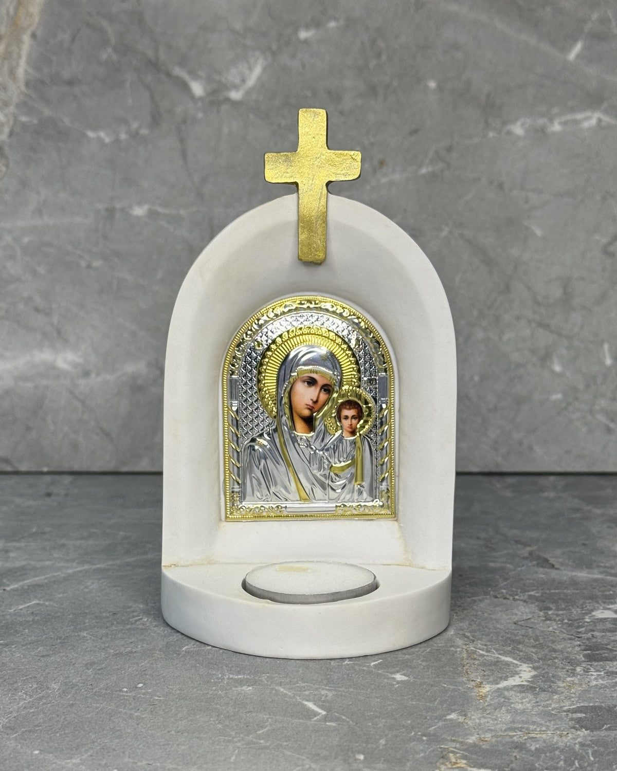 White stone Catholic candle altar with silver Panagia Kazan icon of Mother Mary and Jesus